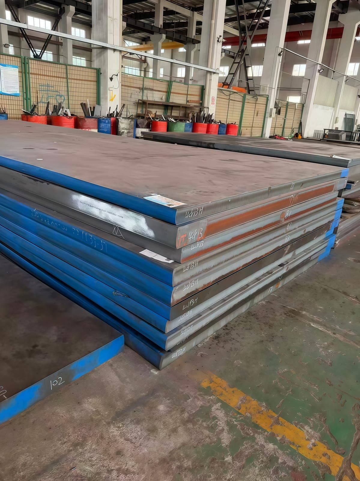 Large plate stock staged inside the processing workshop.